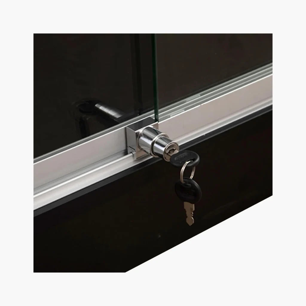 Close-up of a silver metal lock cylinder with two keys inserted, mounted on a glass door frame against a black background.
